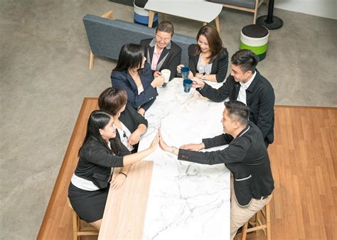 Premium Photo Business People Gathering Around A Table High Five And