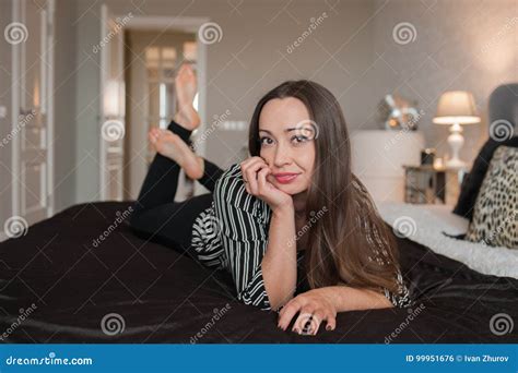 The Brunette Girl Lies On The Bed And Smiles Stock Photo Image Of Lying Brunette
