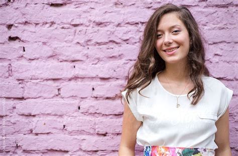 Portrait Of A Cute Brunette Standing Next To A Pink Wall By Stocksy Contributor Jovo