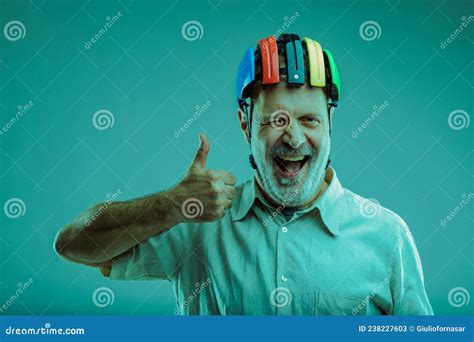 Senior Man Wearing Colourful Bike Helmet Winking And Laughing Stock