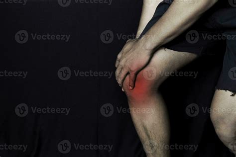 Asian Man Holding his knee. He feels pain on his knee with black