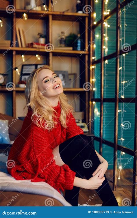 Fashion Blonde Woman In The Red Sweater Sitting On The Bed Stock Image Image Of Clothing Face