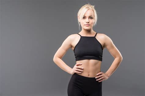 Jeune Fille Blonde Fit Sportive Femme En Vêtements De Sport Noir Démostrate Son Fort étirement