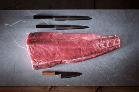 Premium Photo Bluefin Tuna Loin On A Cement Background With Three Knives