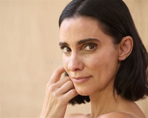 Beauty Portrait Of Smiling Mature Woman With Bare Shoulders Against Natural Background Stock