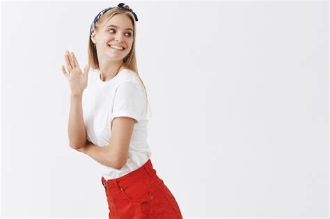 Amusé Coquette Jeune Fille Blonde Posant Contre Le Mur Blanc Photo Gratuite