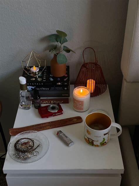 A White Table Topped With A Cup Of Tea Next To A Candle And Other Items