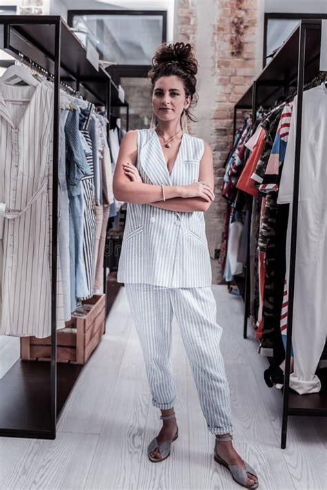Beautiful Owner Of Fashionable Boutique Standing Between The Stands