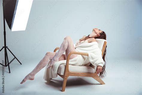 Cozy Photoshoot Studio Woman Portrait Of Sensual Brunette Model In White Coat With Lace Stocking