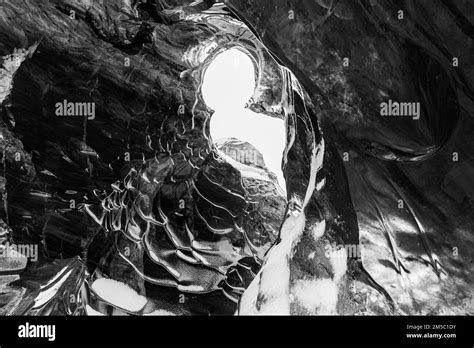 Ice Cave Open To The Top With Snow Covered Ice Combs Black And White