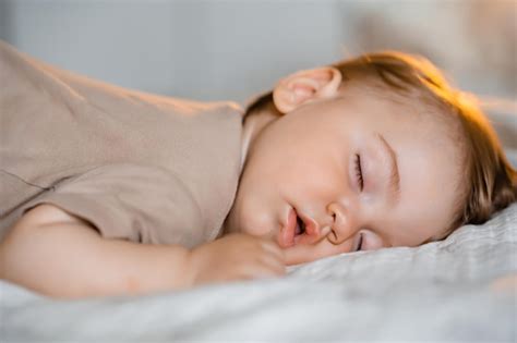 Retrato De Un Bebé Gracioso Durmiendo Boca Abajo En La Cama En Casa
