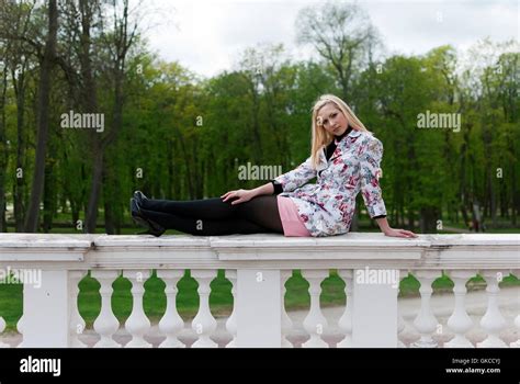 Blonde Girl Sitting On The Railing Stock Photo Alamy