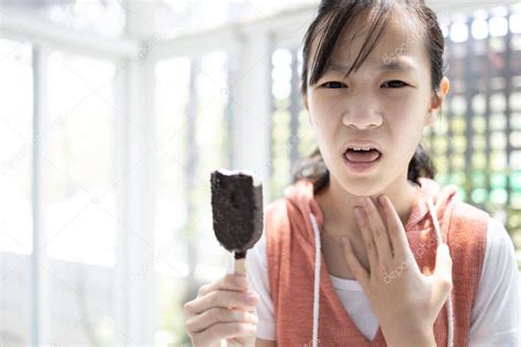 Niña asiática enferma con gripe tos y dolor de garganta comer