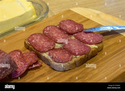 Butter A Slice Of Bread With Butter Sliced Salami And Knife On A