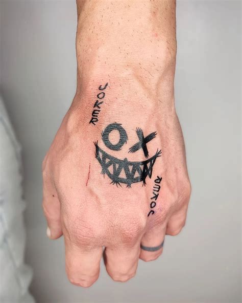 A Persons Hand With A Smiley Face Tattooed On The Left Side Of His Arm