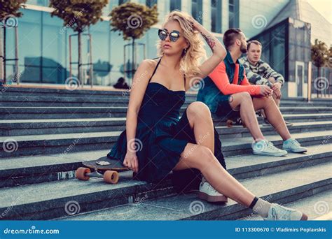 Sexy Blonde Frau Im Schwarzen Kleid Sitzt Auf Einem Longboard Stockfoto Bild Von Extrem