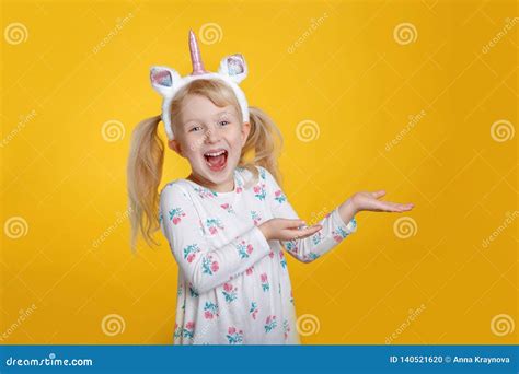 Fille Blonde Caucasienne Dans Le Klaxon Et Des Oreilles De Port De Bandeau De Licorne De Robe