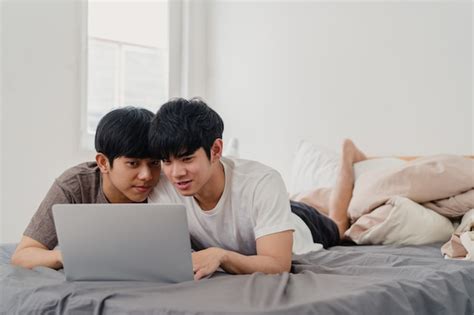 Los hombres asiáticos gay lgbtq se juntan usando la computadora portátil de la computadora en el