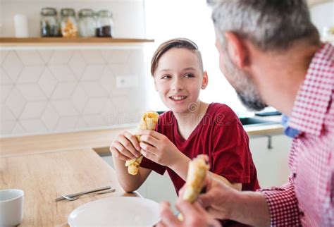 Mature Father With Small Son Indoors Sitting At The Table Eating Pancakes Stock Photo Image