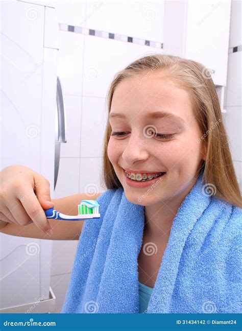 Fille Blonde Avec Des Accolades Souriant Tout En Se Brossant Les Dents Photo Stock Image Du