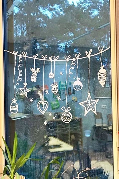 A Window Decorated With Christmas Decorations And Ornaments Hanging