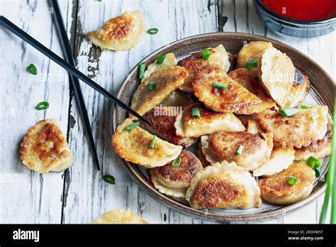 Overhead view of a plate of golden fried Chinese dumplings, also known ...