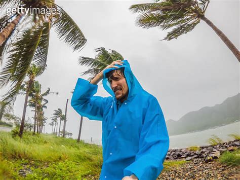 A Man In A Raincoat During Tropical Storm Heavy Rain And High Winds In