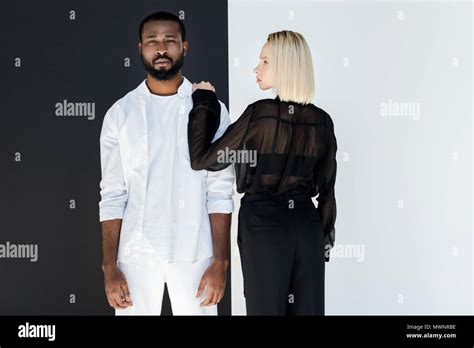 Blonde Girlfriend Touching African American Boyfriend Near Black And White Wall Stock Photo Alamy