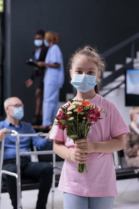 Petite Fille Regardant L Appareil Photo En Tenant Le Bouquet De Fleurs