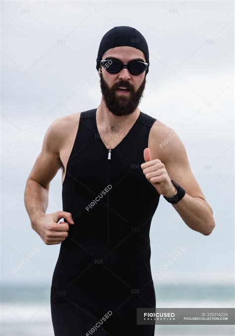 Athlete In Swimming Goggles Running On The Beach — Male Fitness