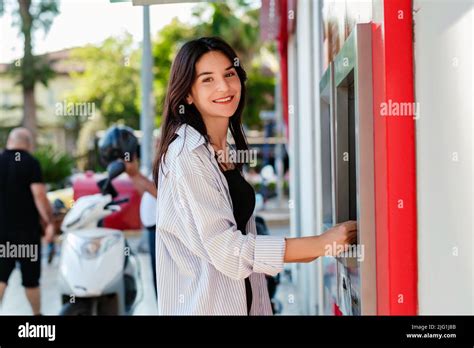 Jeune fille brunette souriante heureuse portant une chemise bleue rayée sur le parc de la ville