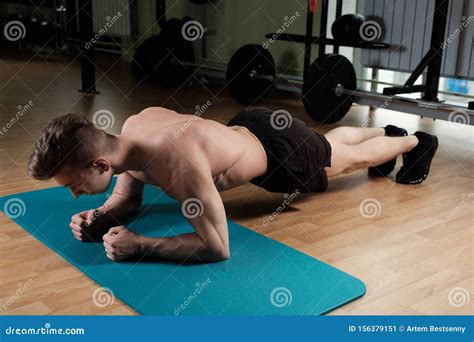 A Muscular Guy With A Naked Torso Stands In A Bar On His Forearms In The Gym Shot From Above