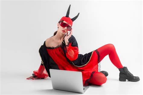 Premium Photo Sexy Brunette Woman In Red Tights Black Boots And Devil Horns Posing With