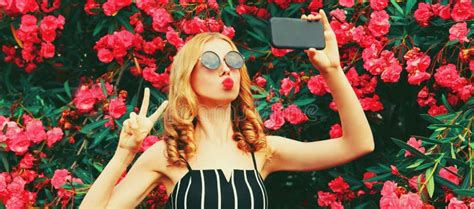 Portrait Of Beautiful Woman Taking Selfie By Smartphone Blowing Her