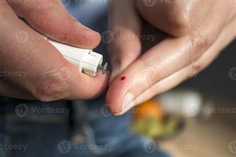 Woman pricking her finger to check blood glucose level with glucometer