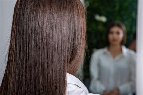 Un cheveu brunette droit et en bonne santé qui a subi la procédure de lissage des cheveux