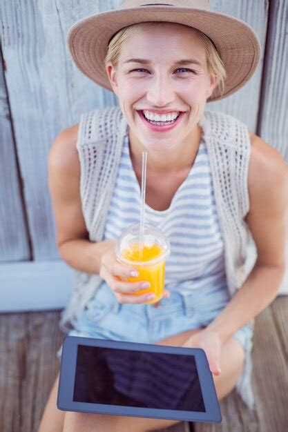 Premium Photo Pretty Blonde Woman Using Her Tablet And Holding Orange Juice