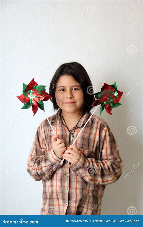 10 Year Old Latina Hispanic Girl Plays With Green White And Red Pennant Flags And Pinwheel To