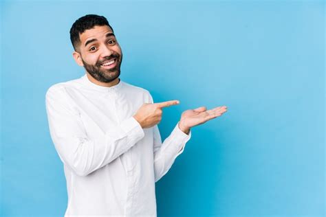 Jovem Latina Contra Uma Parede Azul Animado Segurando Um Espa O Em Branco Na Palma Da M O