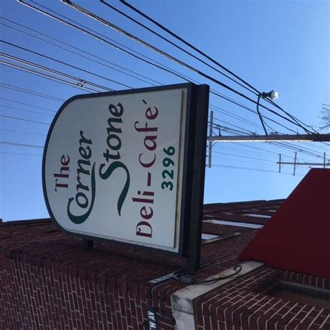 The Corner Store Deli And Cafe Sign In Front Of A Brick Building With