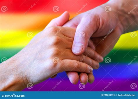 Cierre De Una Pareja Gay Con Las Manos En La Mano Con El Distintivo De La Bandera Arcoiris