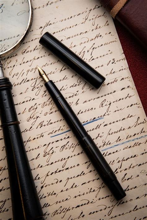 Three Fountain Pens And A Magnifying Glass On Top Of An Old Paper With