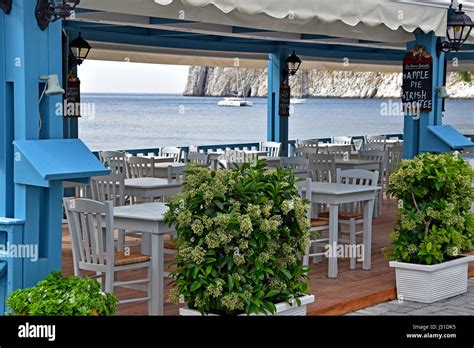 Restaurant overlooking Kamari Beach in Santorini Greece Stock Photo - Alamy