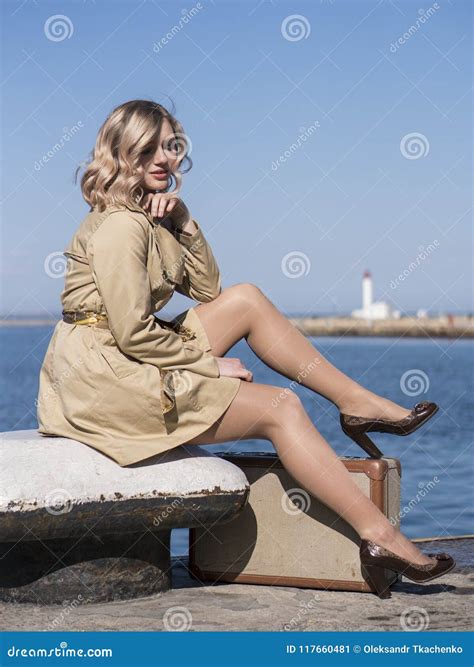 La Jeune Femme Blonde Attirante Dans Le Foss Avec La Valise De Vintage S Assied Sur Le Pilier