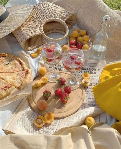 An Assortment Of Food And Drinks On A Picnic Blanket With Strawberries