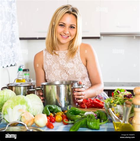 Smiling Blonde Girl Preparing Healthy Meal With Veggies At Home Stock Photo Alamy