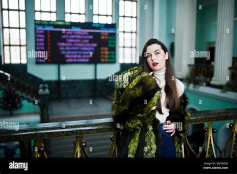 Brunette Girl In Green Fur Coat In Old Hall With Column And Railings