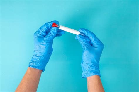 Premium Photo Hand In Blue Gloves Holding A Test Tube