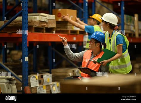 Senior Male Manager In Wheelchair And Young Workers Inspecting Stock