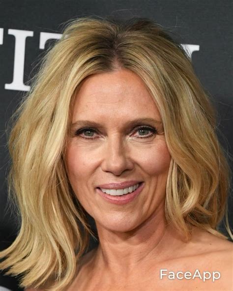 A Woman With Blonde Hair Smiling At The Camera